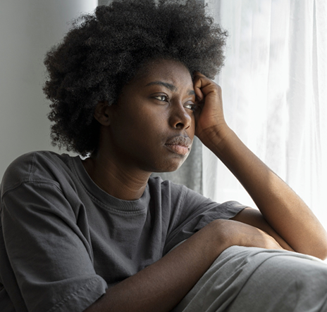 Femme inquiète qui regarde par la fenêtre
