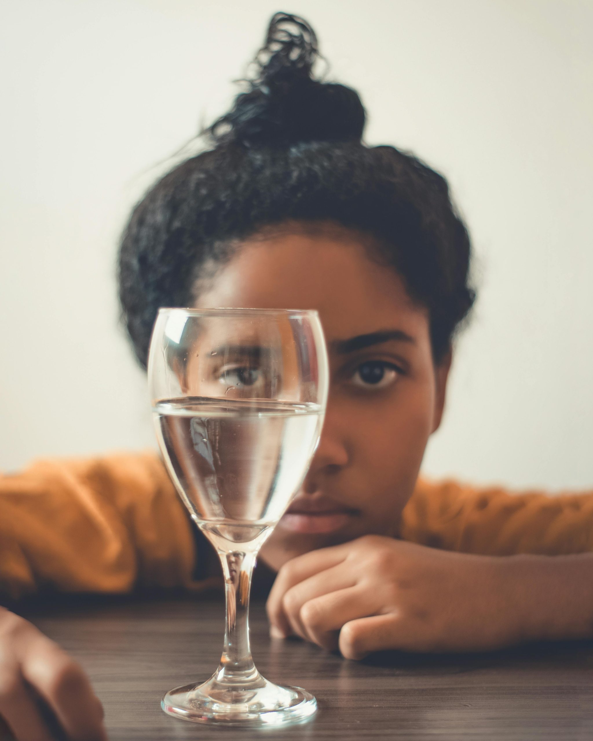 Femme avec un verre d'eau, en illustration des solutions médicamenteuses contre les règles abondantes.