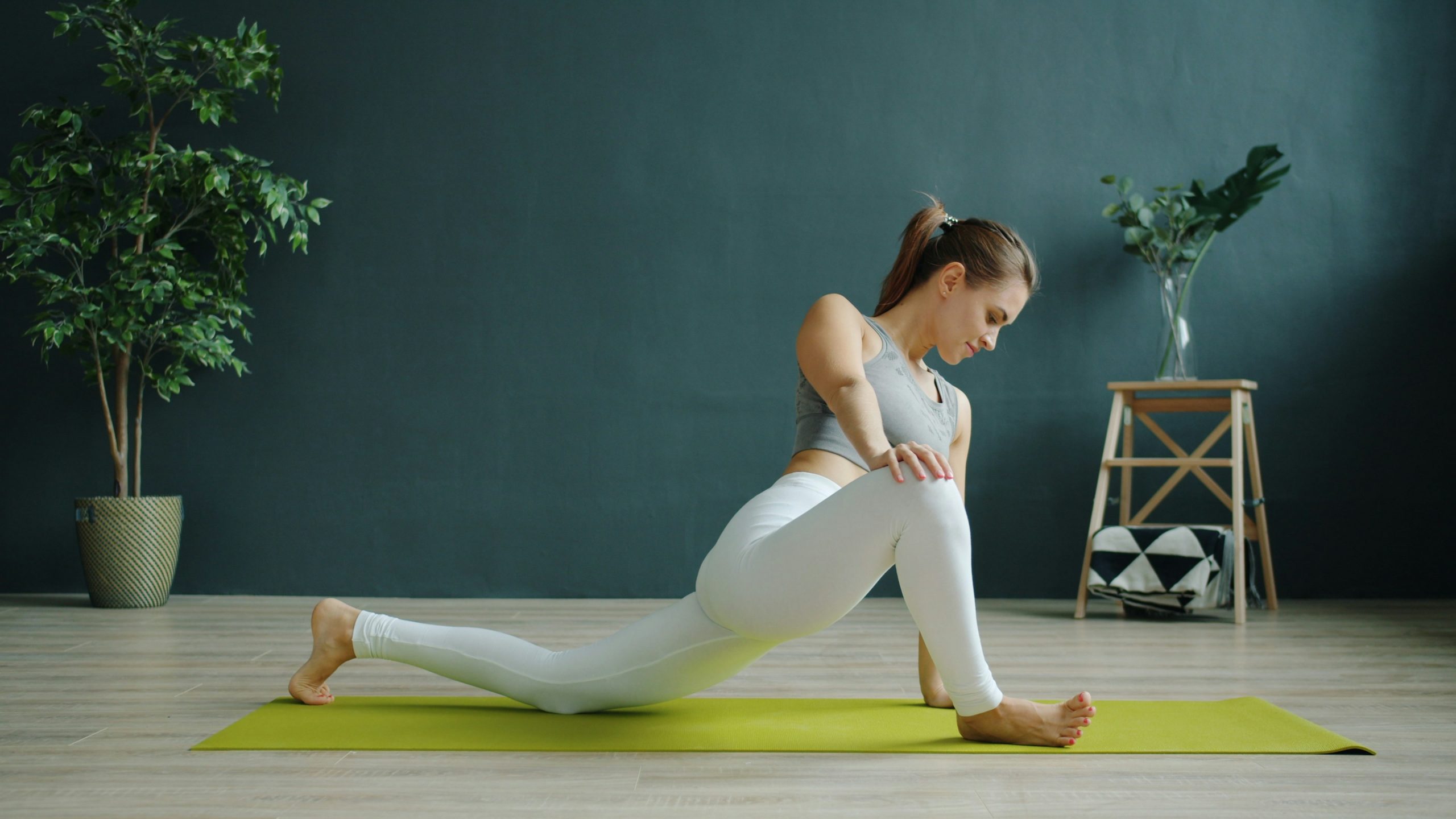 Quel sport pendant les règles : une femme pratiquant des étirements doux au sol, symbolisant le choix d'une activité physique adaptée au flux menstruel.