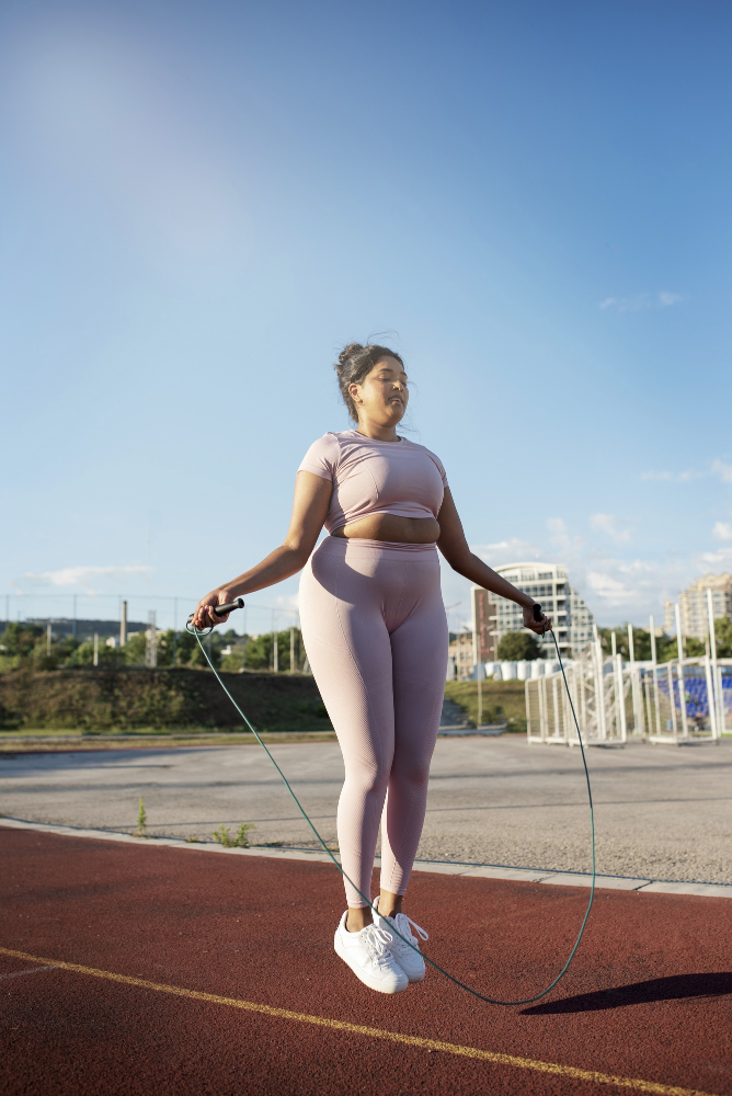 Faire du sport pendant les règles : une femme s'exerçant à la corde à sauter en plein air, en illustration des conseils et solutions pour les règles abondantes.